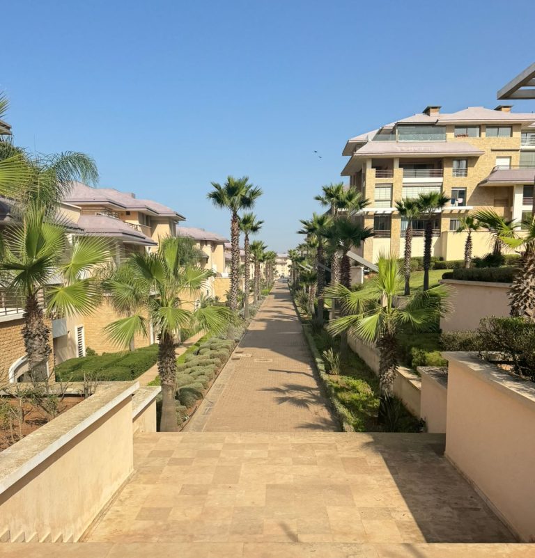 Vue panoramique d'un quartier résidentiel haut de gamme à Rabat avec des villas modernes et des espaces verts.